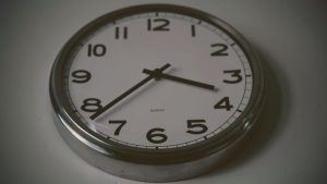 round silver wall clock with white face and black numbers