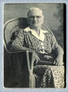 older white haired woman, my great grandmother, sitting in a wicker chair