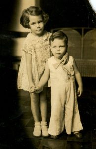 black and white picture of a little girl, (my mother), holding her younger brother
