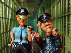 one male and one female police officer figurines in a jail hallway