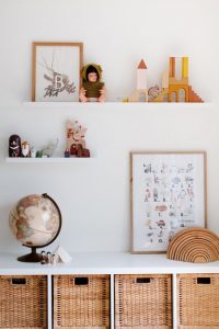 decorations on organized floating shelves over a desk with a globe and wicker baskets